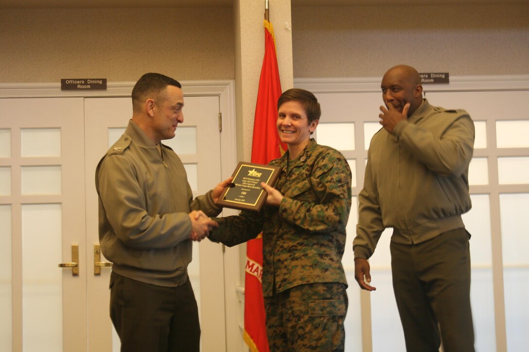 Capt. Bridgett Skelton accepts an award presented by MCBQ Commander Col. Joseph Murray to The Basic School for most improved participation for a large unit in the 2015 Combined Federal Campaign. The award was presented at a ceremony on Feb. 11.