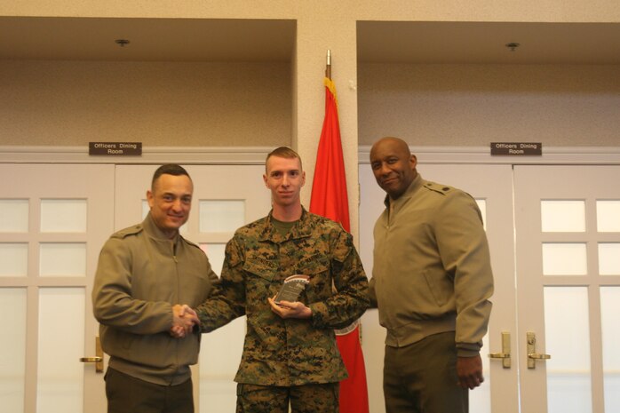 Cpl. Vernon Saunders, Marine Corps Air Facility Quantico, stands between Col. Joseph Murray, MCBQ Commander, and Sgt. Maj. Gerald Saunders, with a Hero Award he received for service to the 2015 Combined Federal Campaign.