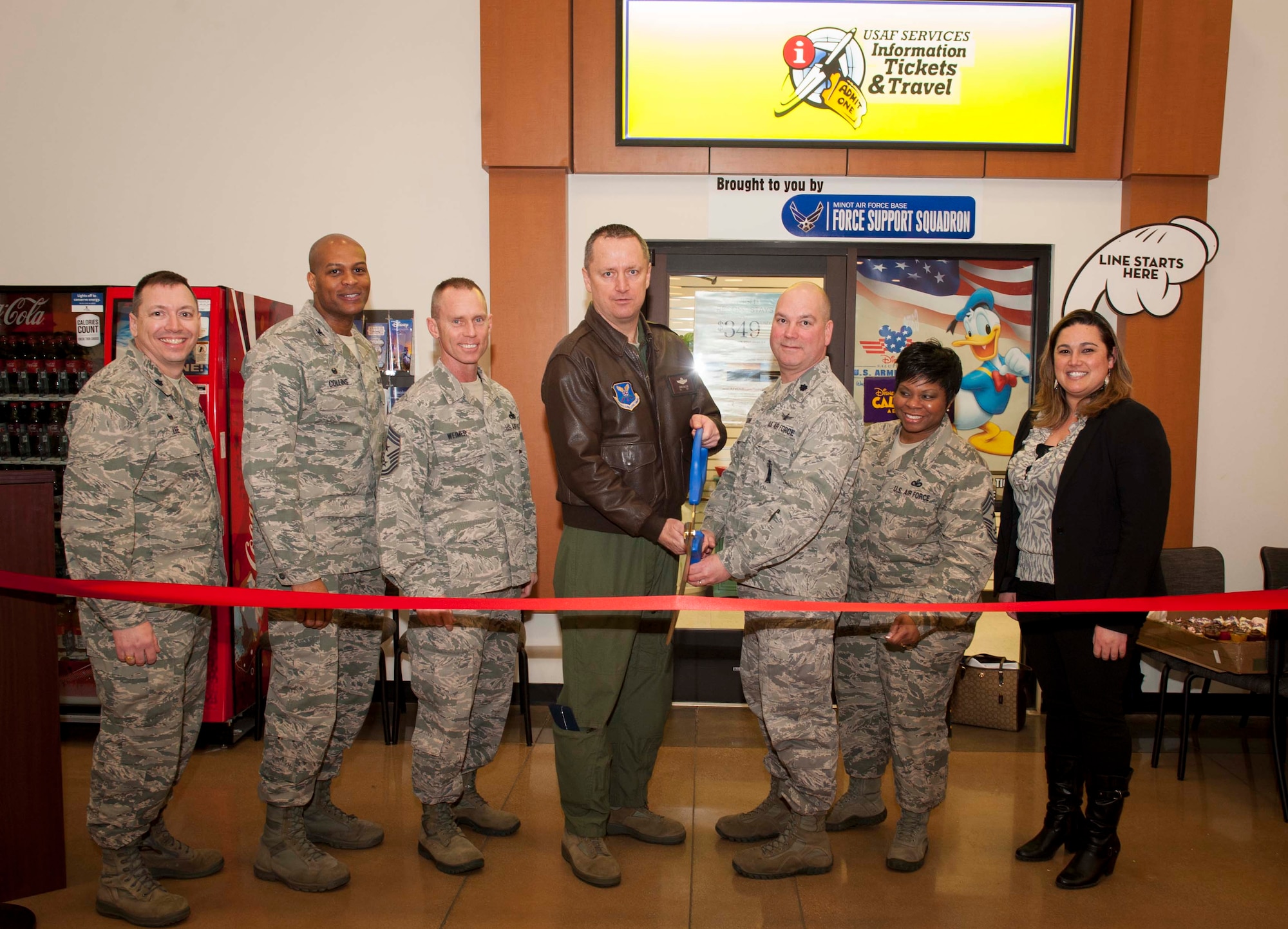 Base leadership cuts a ribbon to the new Information, Tickets and Travel office at Minot Air Force Base, N.D., Feb. 17, 2016. The ITT office, located in the Base Exchange, provides customers with packages on hotel reservations, maps, brochures on their areas of interest and discount tickets for events and venues. (U.S. Air Force photo/Senior Airman Sahara L. Fales)
