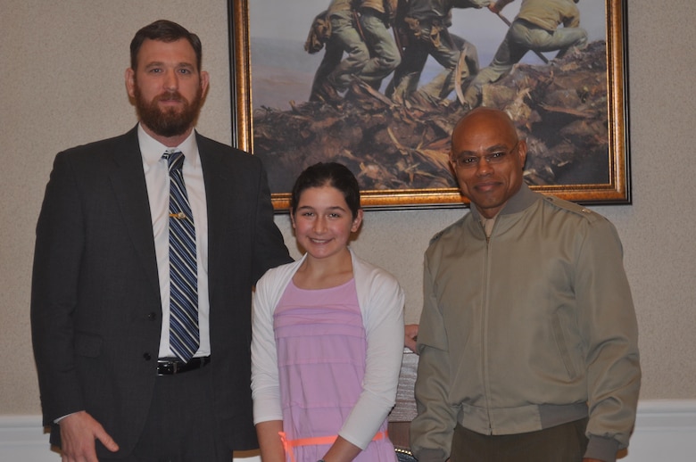Mayor Kevin Brown and Lt. Col. Douglas Lemott, Jr. present Jenny, age 12, a homeschooler, with the award for winning the Black History Month essay contest in the middle school category.