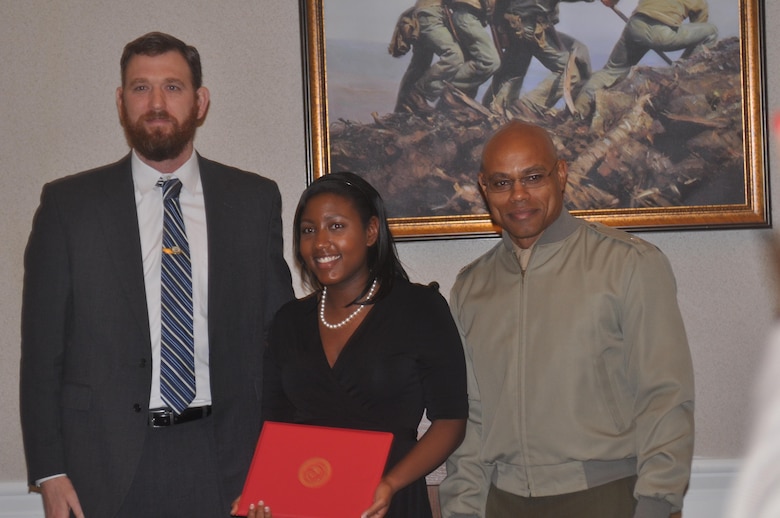 Mayor Kevin Brown and Lt. Col. Douglas Lemott, Jr. present Paige, age 17, with the award for winning the Black History Month essay contest in the high school category.