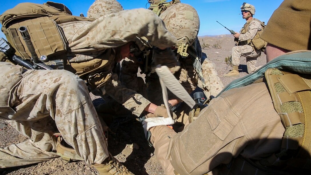 Marines and Sailors with Company F, 2nd Battalion, 7th Marine Regiment, 1st Marine Division, provide first aid on a simulated casualty during tactical recovery of aircraft and personnel training aboard Marine Corps Air Ground Combat Center Twentynine Palms, Calif., Feb. 4, 2016. The training will better prepare 2/7 for their upcoming deployment to the Central Command area of responsibility as the ground combat element for Special Purpose Marine Air Ground Task Force Crisis Response Central Command 16.2, where they will be positioned to conduct TRAP missions in support of Operation Inherent Resolve. (U.S. Marine Corps photo by Cpl. Danielle Rodrigues/Released)