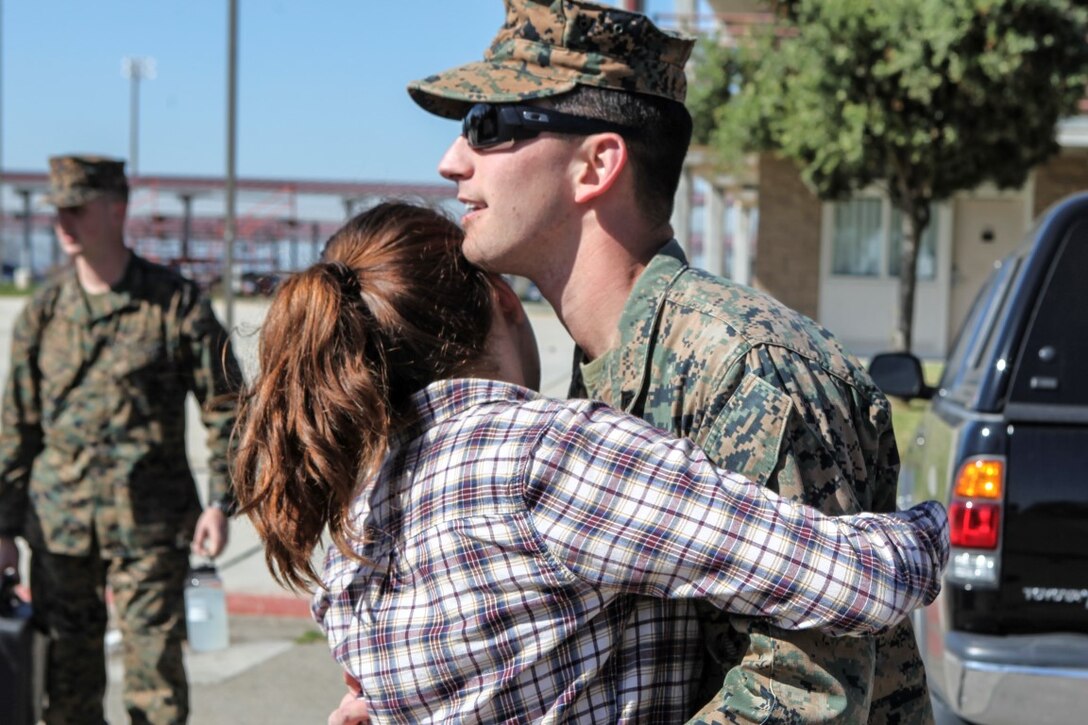 A Marine spends his final moments with loved ones before loading onto a bus during a farewell gathering for the Marines and sailors of the 13th Marine Expeditionary Unit Feb. 11, 2016. Service members with 13th MEU are deploying as part of the Boxer Amphibious Ready Group to the Western Pacific and the Middle East. The gathering was held on Camp Pendleton. (U.S. Marine Corps photo by Sgt. Jessica Ostroska/Released)