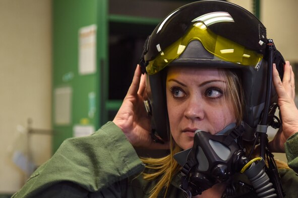 Tiffany Dear, wife of Staff Sgt. Chris Dear, 4th Aircraft Maintenance Squadron crew chief, tries on a helmet, Feb. 16, 2016, at Seymour Johnson Air Force Base, North Carolina. Spouses of the 4th AMXS and 335th Fighter Squadron were fitted with aircrew flight equipment before taxi rides around the flightline. (U.S. Air Force photo/Airman Shawna L. Keyes)