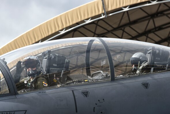 First Lt. Brandon Wampler (left), 335th Fighter Squadron pilot, and Leslie Wight, wife of Capt. Taylor Wight, 335th FS pilot, wave as they begin to taxi down the flightline, Feb. 16, 2016, at Seymour Johnson Air Force Base, North Carolina. The 335th FS and 4th Aircraft Maintenance Squadron spouses got the opportunity to see what goes into prepping for a flight. (U.S. Air Force photo/Airman Shawna L. Keyes) 