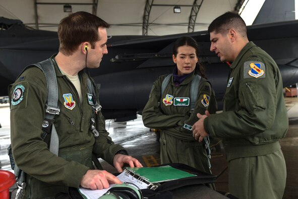 First Lts. Brandon Wampler (left), and Adam Becker (right), both 335th Fighter Squadron pilots, instruct Leslie Wight, wife of Capt. Taylor Wight, 335th FS pilot, on pre-flight checks, Feb. 16, 2016, at Seymour Johnson Air Force Base, North Carolina. Spouses of air and ground crews received briefings on the ins-and-outs of what happens on a daily basis within the squadrons. (U.S. Air Force photo/Airman Shawna L. Keyes)