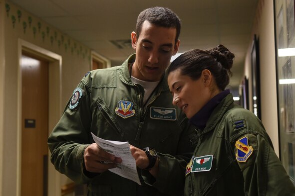 Capt. Taylor Wight (left), 335th Fighter Squadron pilot, shows his wife, Leslie, the schedule for the day, Feb. 16, 2016, at Seymour Johnson Air Force Base, North Carolina. Spouses wore flight suits with specialized name tags during their F-15E Strike Eagle taxi rides. (U.S. Air Force photo/Airman Shawna L. Keyes)