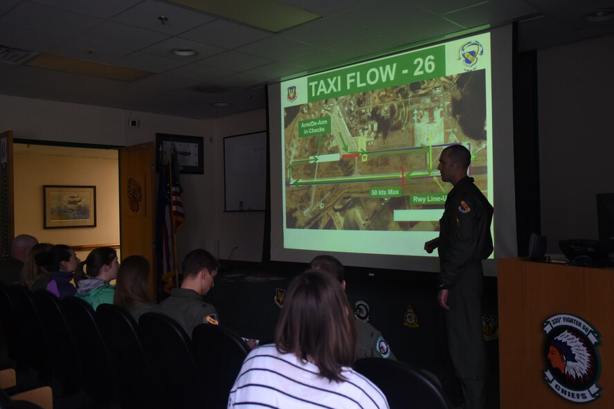 Capt. Wes Szempruch, 335th Fighter Squadron chief of training, gives a briefing to spouses of members of the 335th FS and 4th Aircraft Maintenance Squadron, Feb. 16, 2016, at Seymour Johnson Air Force Base, North Carolina. Spouses received a brief, tour of the squadron and an F-15E Strike Eagle taxi ride. (U.S. Air Force/Airman Shawna L. Keyes)