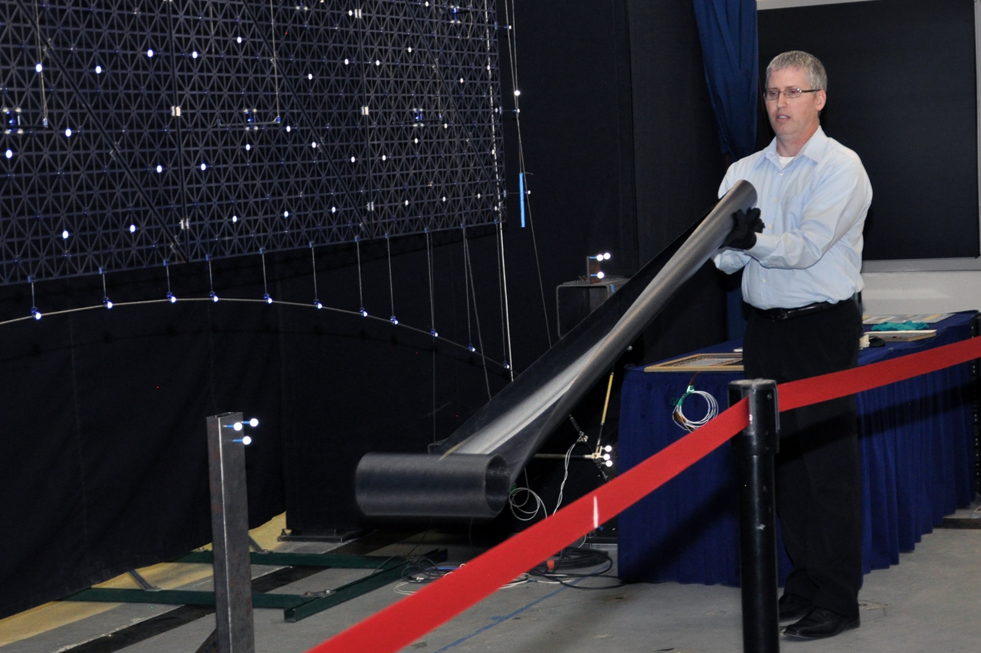 Air Force Research Laboratory scientist Paul Hausgen demonstrates deploying the composite Roll-Out Solar Array slit-tube boom. The booms do not require external power, but deploy under their own stored strain energy. AFRL was selected to receive a 2016 Excellence in Technology Transfer Award for ROSA, a technology which revolutionizes how satellites are powered, (Photo by  Anita Collins)
