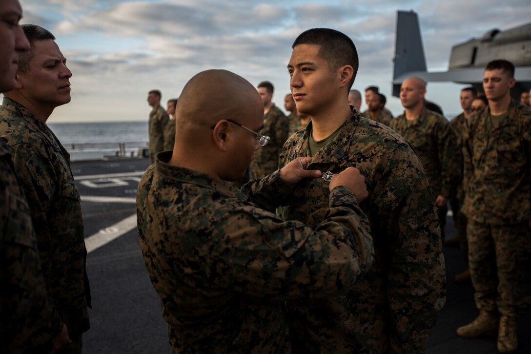 U.S. Navy Hospital Corpsman 3rd Class Nicolas Biscocho with Combat Logistics Battalion 13, Boxer Amphibious Ready Group/13th Marine Expeditionary Unit receives an Enlisted Fleet Marine Force Warfare Specialist Qualification device during a formation aboard the USS New Orleans, February 16, 2016. The device signifies the completion of the Fleet Marine Force Qualification training that Navy Corpsmen take to familiarize themselves with the Marine Corps. (U.S. Marine Corps photo by Sgt. Tyler C. Gregory/released)