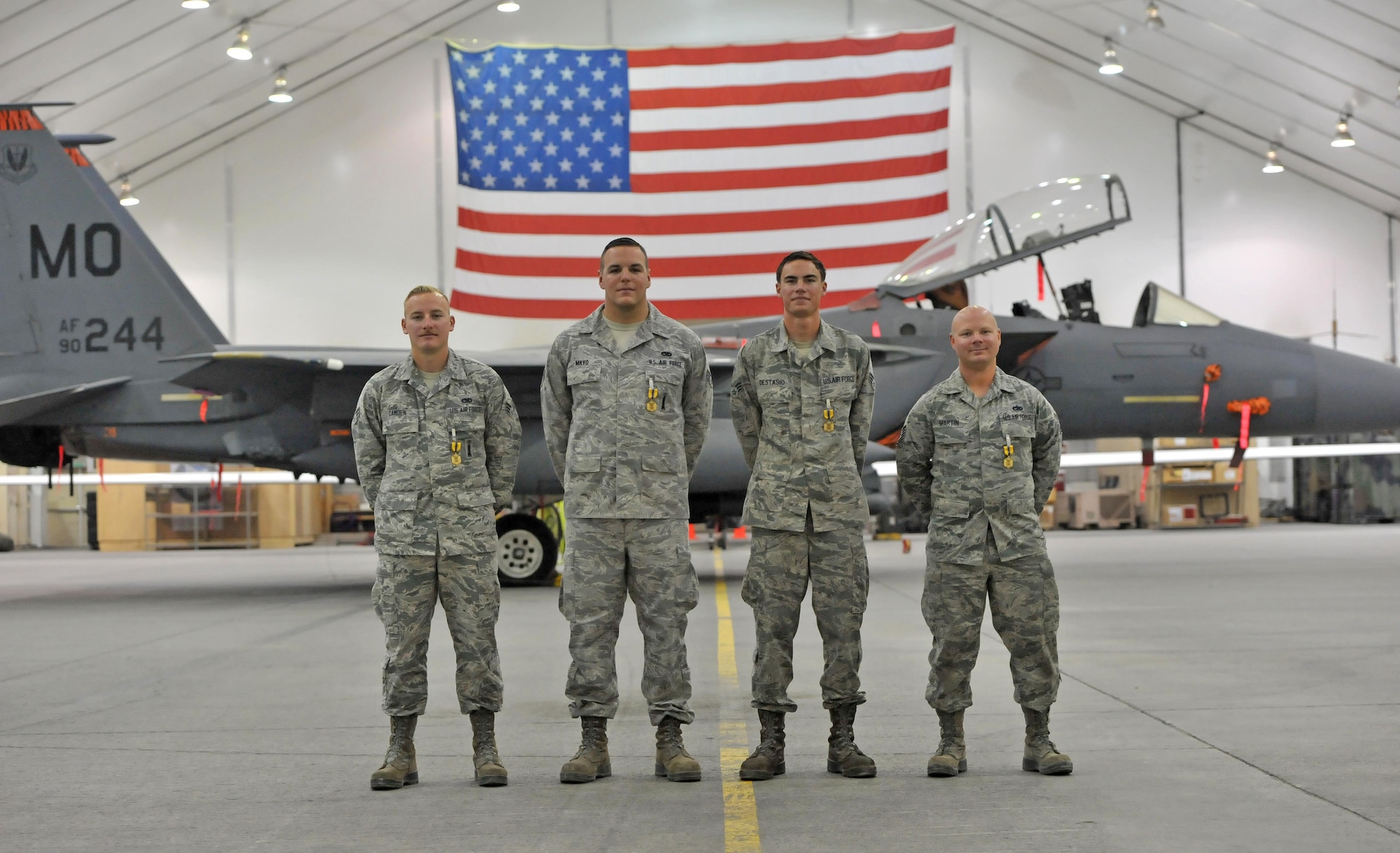 Senior Airmen Nash Camden, Matthew Mayo, Blake Destasio and Tech. Sgt. Kyle Martin, left to right respectively, pose for a photo after an awards ceremony at an undisclosed location in Southwest Asia, Feb. 16, 2016. The four Airmen were part of a group of nine maintainers from the 380th Expeditionary Aircraft Maintenance Squadron who were recognized for their efforts when they responded to a fire caused by a hydraulic fluid leak on an F-15E Strike Eagle fighter after it returned from a sortie December 2015. (U.S. Air Force photo by Staff Sgt. Kentavist P. Brackin/Released)