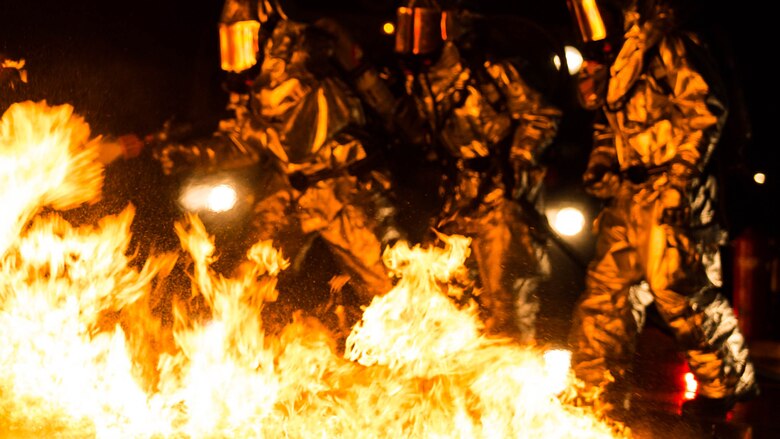 Marines extinguish a fire during a controlled burn training exercise aboard Marine Corps Air Station Beaufort Feb. 17. The Marines are wearing heat resistant suits that can withstand up to 2,100 degrees of heat and a breathing apparatus attached to a canister that provides them oxygen as they navigate through the fire. The Marines are with Aircraft Rescue and Firefighting. 