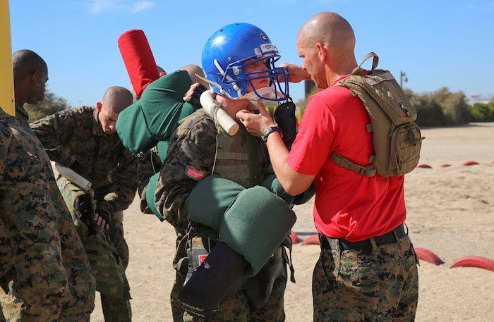 A drill instructor of Alpha Company, 1st Recruit Training Battalion, inspects a recruit’s gear before his match during the Pugil Sticks I event at Marine Corps Recruit Depot San Diego, Feb. 10. Recruits were given protective gear such as a helmet, groin protector and flak jacket for safety. Annually, more than 17,000 males recruited from the Western Recruiting Region are trained at MCRD San Diego. Alpha Company is scheduled to graduate April 22.