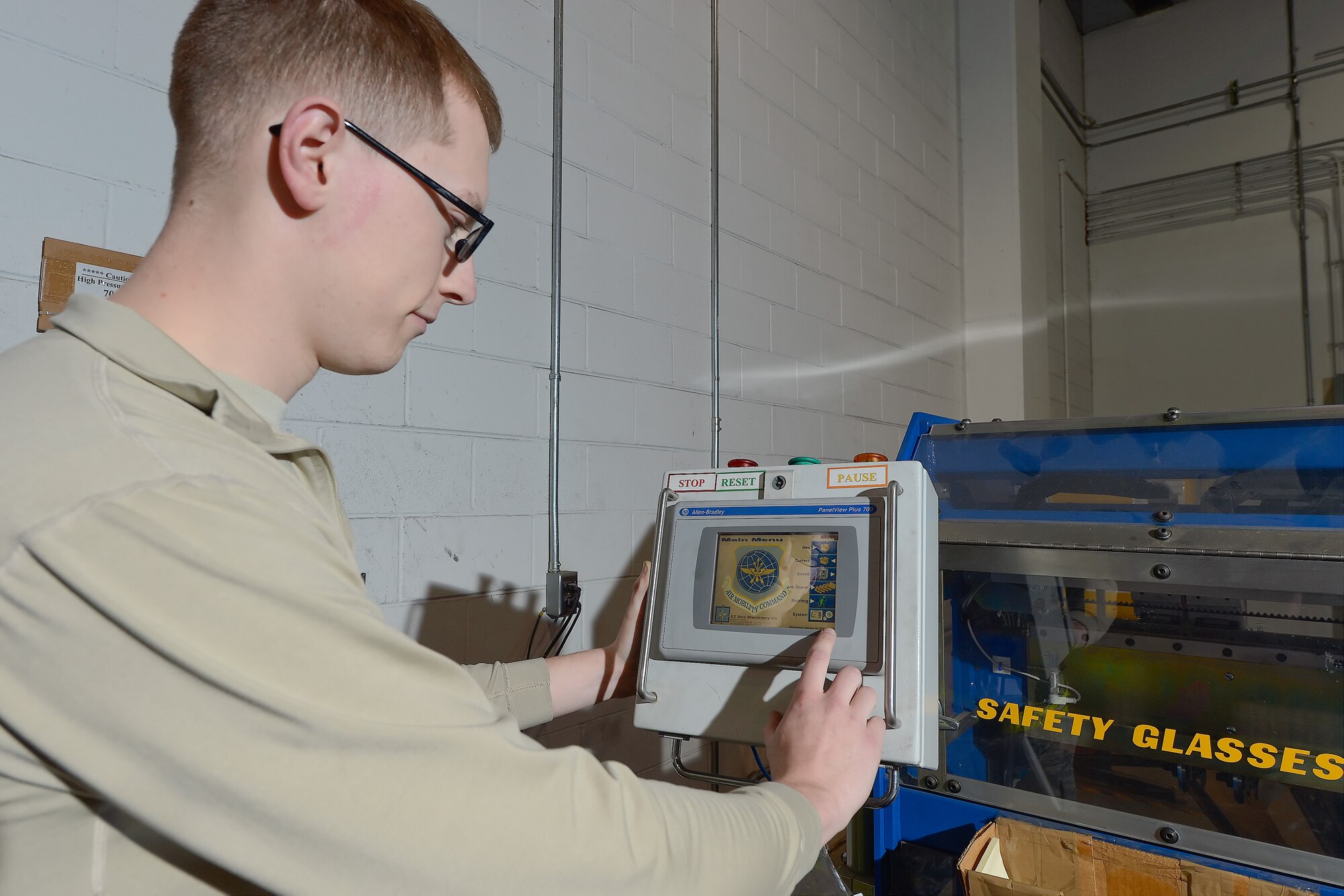 Senior Airman Christopher Shields, 436th Aerial Port Squadron packing and crating clerk, uses a computer terminal to input custom box dimensions into the EZ Box Maker machine Feb. 10, 2016, at Dover Air Force Base, Del. The money-saving machine has saved the Air Force hundreds of thousands of dollars by creating boxes sized to the item to be shipped versus pre-purchased boxes. (U.S. Air Force photo/Greg L. Davis)