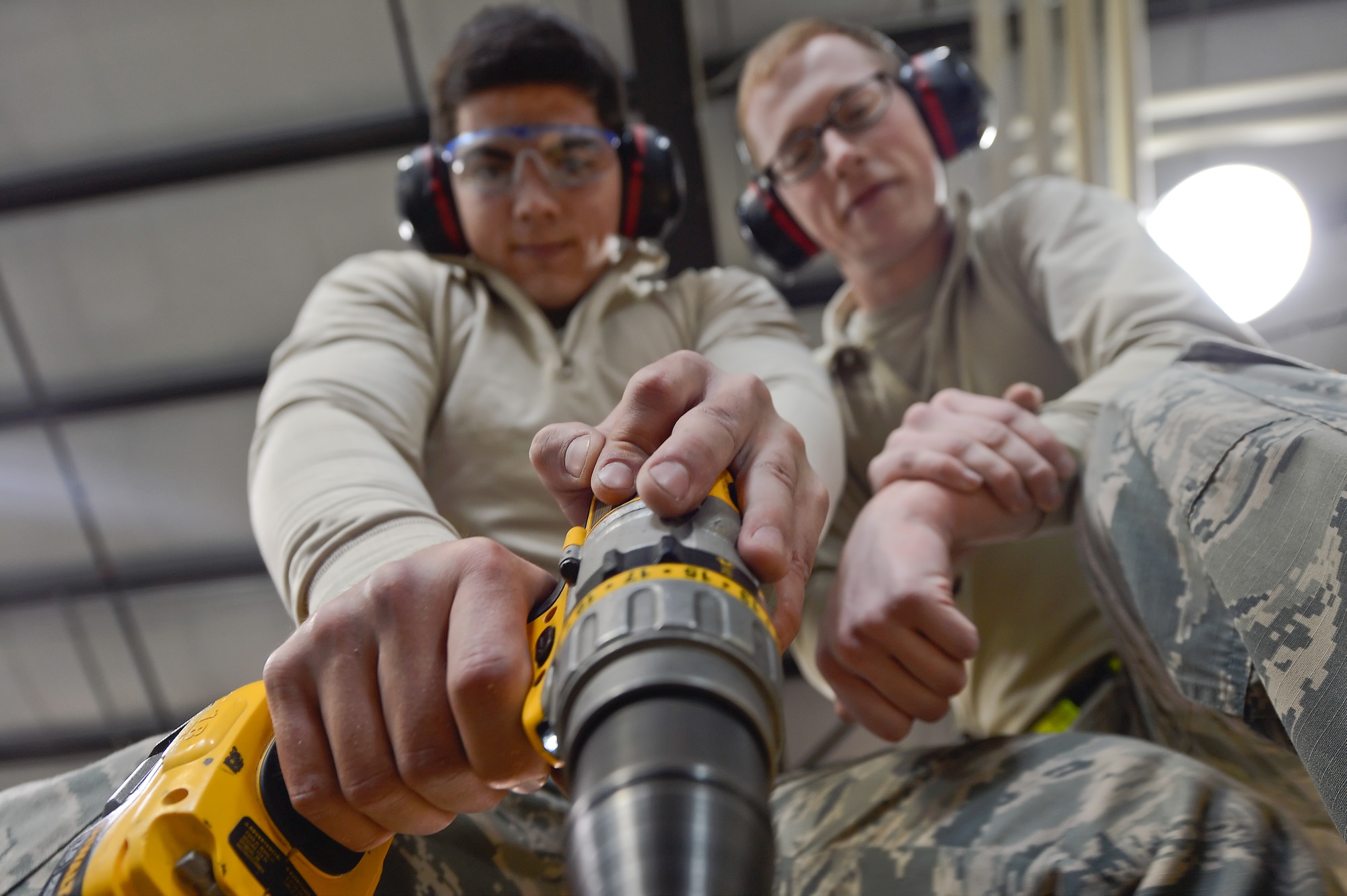 Airman 1st Class Yasel Berrocal, 436th Aerial Port Squadron packing and crating clerk, left, presses down on a screw-gun to fasten in wood screws while Senior Airman Christopher Shields, 436th APS packing and crating clerk, assists as they build a crate Feb. 10, 2016, at Dover Air Force Base, Del. The clerks are building a specialized replacement crate for transporting aircraft components. (U.S. Air Force photo/Greg L. Davis)