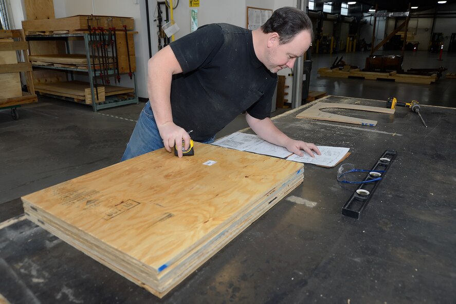 Patrick Brady, 436th Aerial Port Squadron packing and crating clerk, reviews plans for a crate he is building Feb. 10, 2016, at Dover Air Force Base, Del. Brady, as a civilian employee, passes along his knowledge to APS Airmen as part of a team that saves the Air Force thousands of dollars. (U.S. Air Force photo/Greg L. Davis)