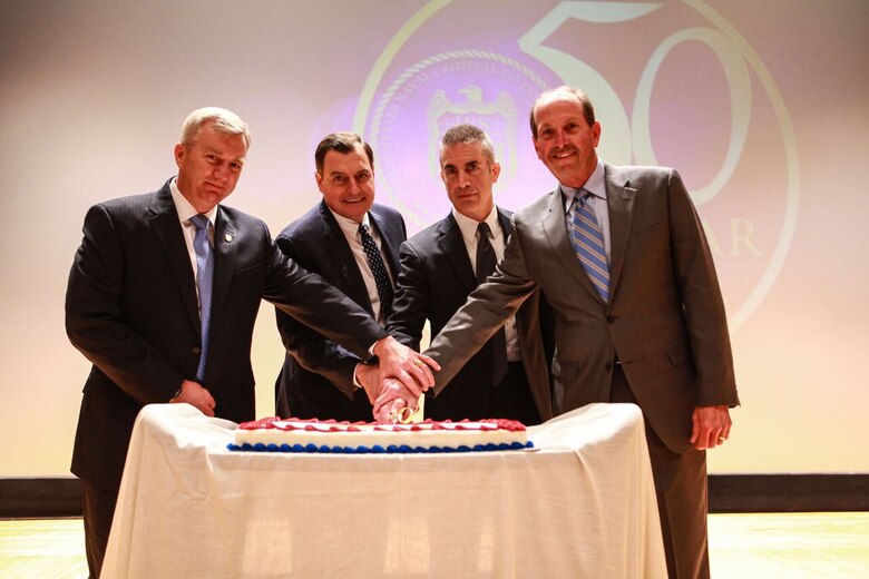 NCIS Director Andrew L. Traver and three former directors cut a cake commemorating the agency’s 50th anniversary during a ceremony at Marine Corps Base Quantico’s Little Hall Theater. Left to right:  Mark D. Clookie, Thomas A. Betro, Traver and David L. Brant.