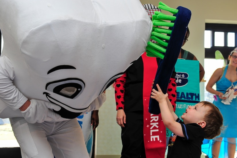 Patrick Miller, 628th Medical Group chief of preventative dentistry, leans in to allow Jaxon Baber to “brush” him. Miller and his team visited the child development center to promote good dental hygiene for children’s dental health month on Joint Base Charleston – Air Base, S.C., on Feb 10, 2016. (U.S. Air Force photo/Airman 1st Class Thomas T. Charlton)