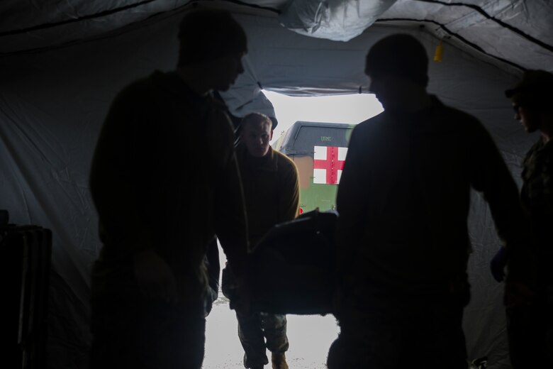 U.S. Marines with the 2nd Marine Expeditionary Brigade carry a notional Norwegian soldier casualty into a medical tent during combat casualty care training at Rena, Norway, Feb. 17, 2016. Through simulated mass casualty injuries, the Marines and sailors were able to conduct realistic casualty care on their Norwegian counterparts while also incorporating some of the host nation’s medical equipment. The two countries are coming together for Exercise Cold Response 16 in March, which combines the efforts of 12 NATO allies and partner nations to enhance joint crisis response capabilities in cold weather environments. (U.S. Marine Corps photo by Cpl. Lucas Hopkins/Released)