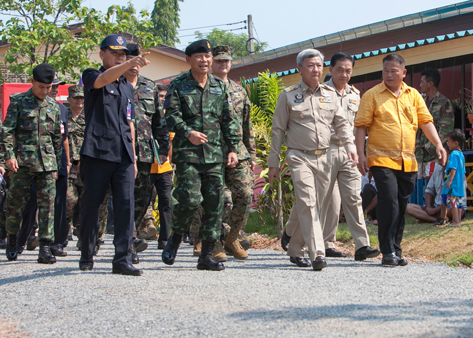 Distinguished visitors walk to the reviewing area to begin the dedication ceremony of a one-room multi-purpose educational building Feb. 18 at Ban Sa Yai, Trat, Thailand. The construction at Ban Sa Yai was one of six humanitarian civic action sites in which the Thai, U.S. and partner nation’s militaries will worked together on civic programs during Cobra Gold 2016. The HCA programs will help improve the quality of life, as well as the general health and welfare of civilian residents in the exercise areas.  