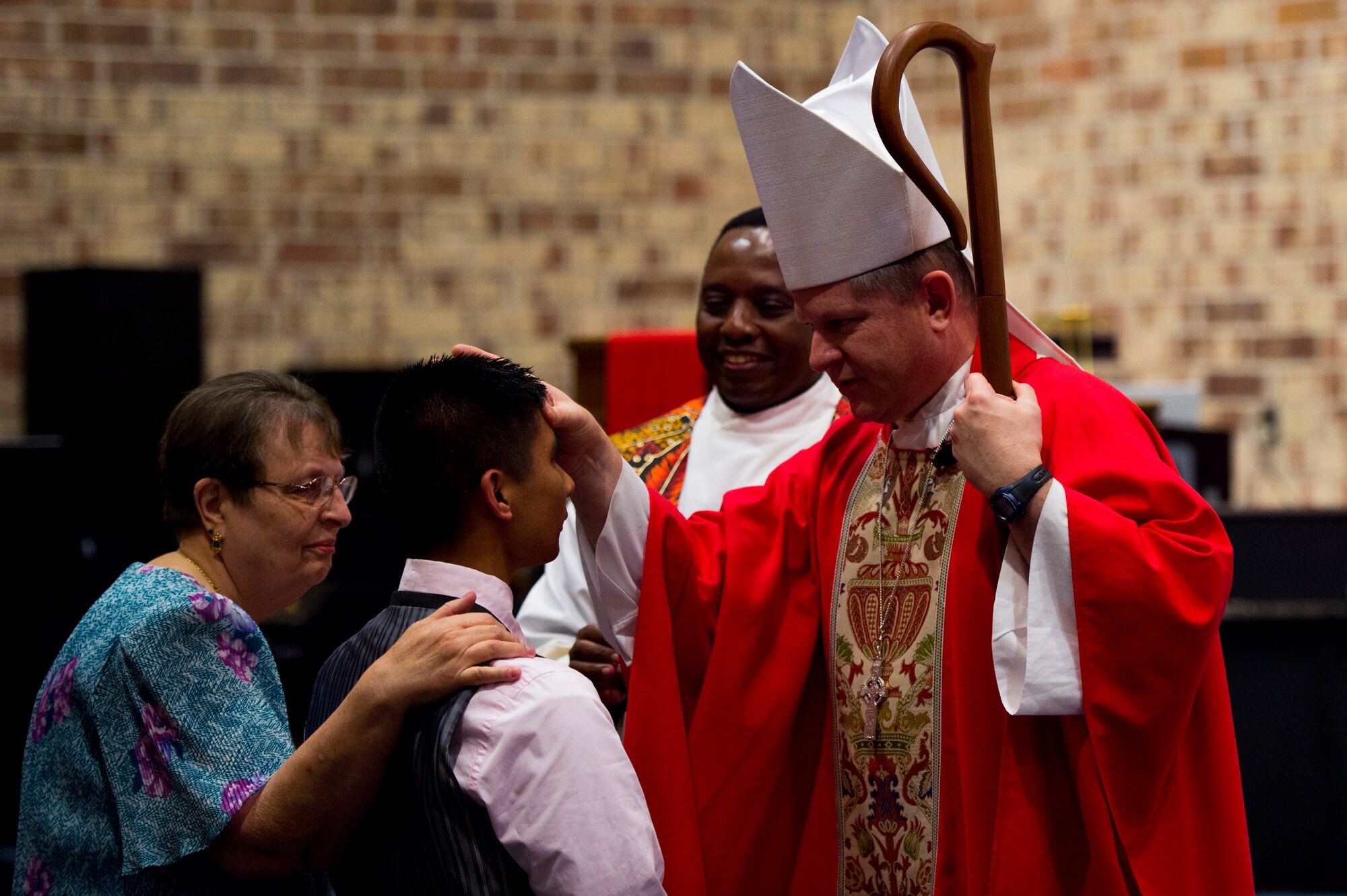Bishop Robert Coyle, Archdiocese for the Military Service, anoints U.S. Air Force Airman 1st Class Vernon Bautista, 723d Aircraft Maintenance Squadron, during Confirmation Mass, Feb. 16, 2016, at Moody Air Force Base, Ga. Bautista was one of 11 people who participated in the Sacrament of Confirmation, which Catholics believe more perfectly binds the confirmation candidate to the Church and enriches them with the Holy Spirit. (U.S. Air Force photo by Staff Sgt. Eric Summers Jr./Released)