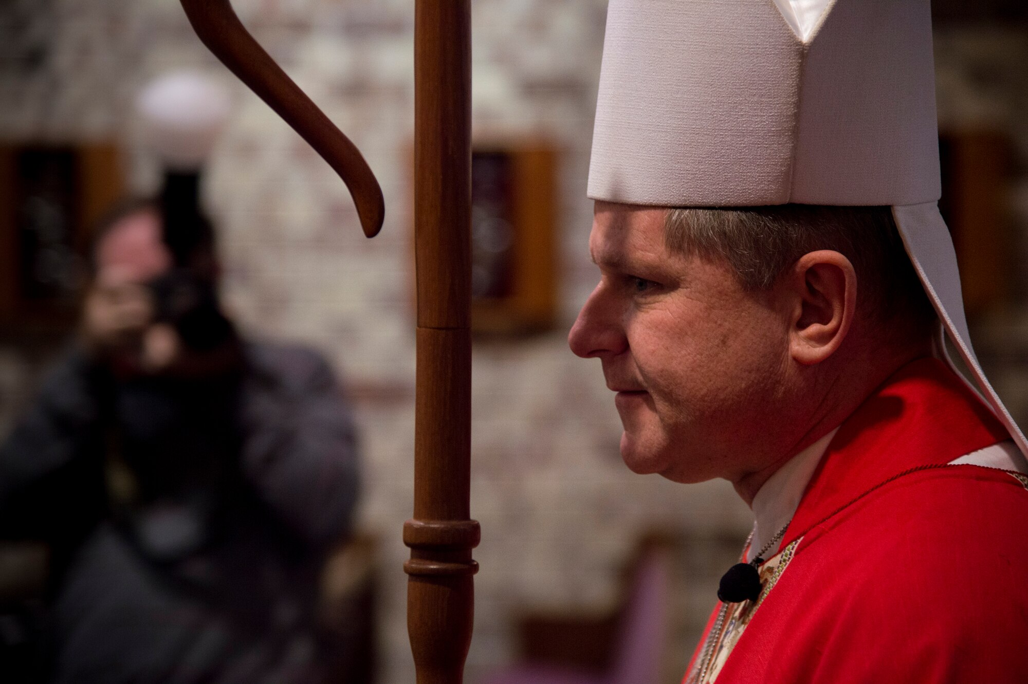 Bishop Robert Coyle, Archdiocese for the Military Service, walks down the aisle to begin Confirmation Mass, Feb. 16, 2016, at Moody Air Force Base, Ga. Coyle visited Moody to help 11 members of Team Moody embark on the next stage of their religious journey. (U.S. Air Force photo by Staff Sgt. Eric Summers Jr./Released)