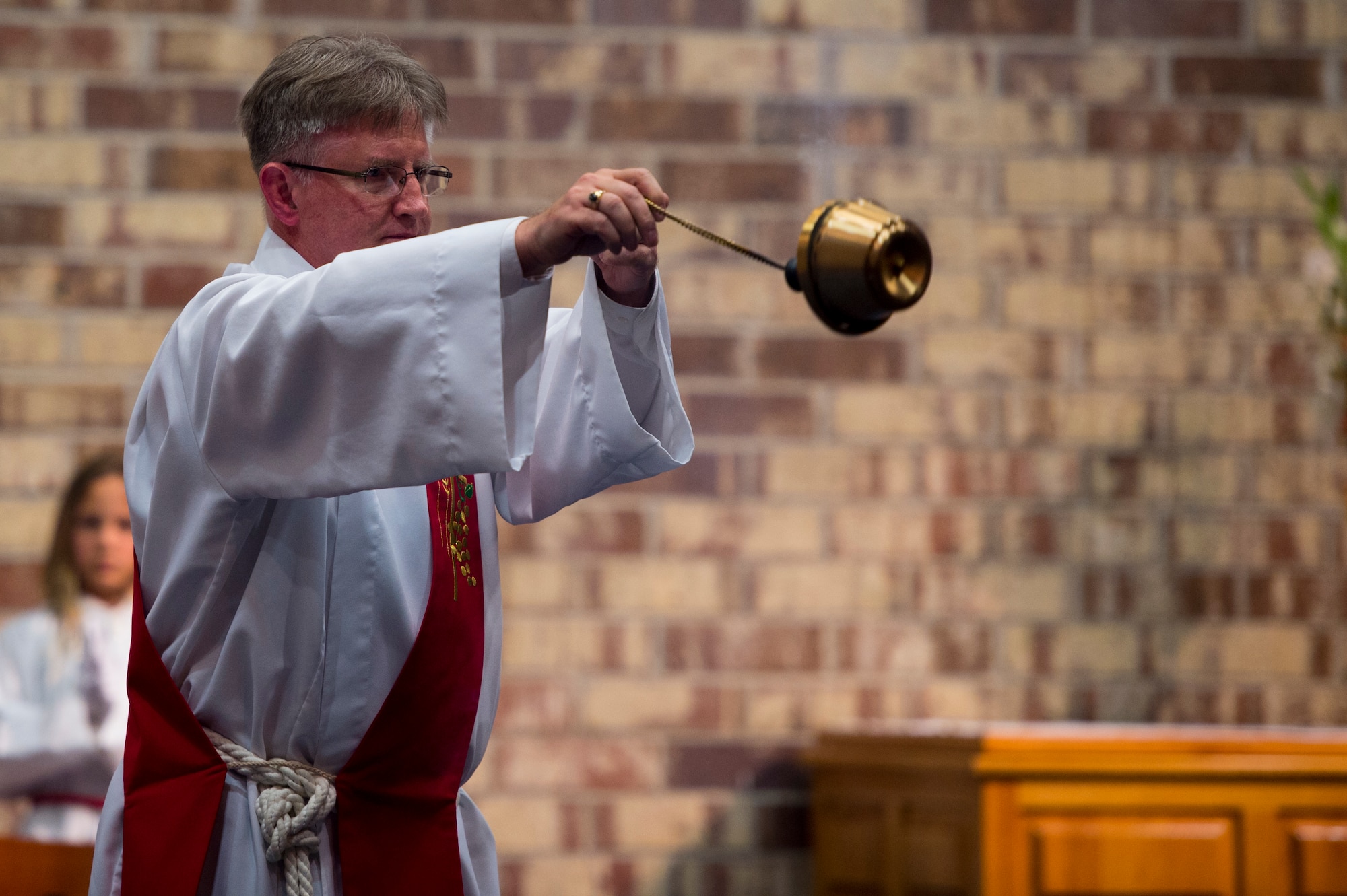 Deacon Peter Falkenhausen, 23d Wing Safety, waves incense during Confirmation Mass Feb. 16, 2016, at Moody Air Force Base, Ga. The incense smoke is symbolic to the values of purification and sanctification. (U.S. Air Force photo by Staff Sgt. Eric Summers Jr./Released)