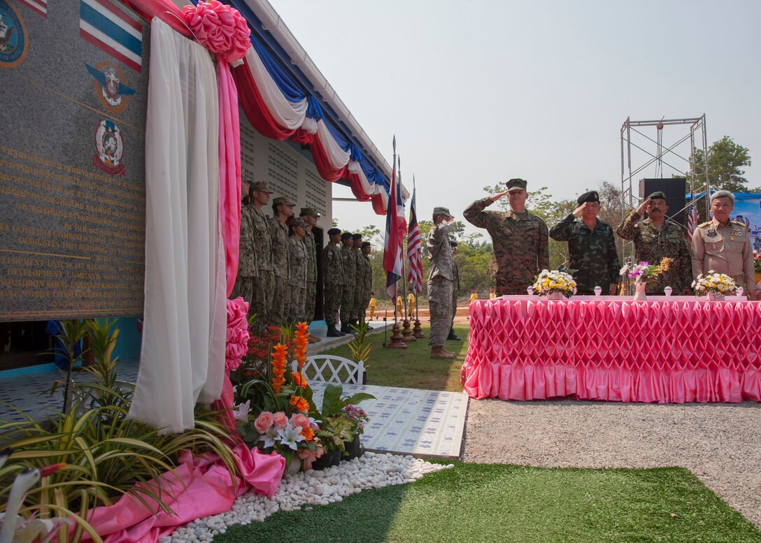 Left to right: U.S. Marine Corps Brig. Gen. Russell Sanborn, commanding general of 1st Marine Aircraft Wing, III Marine Expeditionary Force; Royal Thai Army Gen. Wichien Sirisoonthorn, Royal Thai Armed Forces Headquarters ; Malaysian Army Lt. Col. Made Trika, Malaysian Armed Forces; Mr. Channa Eiumsang, governor of Trat Province. The distinguished visitors render honors during the unveiling of the one-room multi-purpose educational building dedicated Feb. 18 at Ban Sa Yai, Trat, Thailand. The construction at Ban Sa Yai was one of six humanitarian civic action sites in which the Thai, U.S. and partner nation’s militaries will worked together on civic programs during Cobra Gold 2016. Cobra Gold, in its 35th iteration, demonstrates the commitment of the Kingdom of Thailand and the U.S. to our long-standing alliance and regional partnership toward advancing prosperity and security in the Indo-Asia Pacific region.  (U.S. Marine Corps photo by SSgt. Jose O. Nava/Released)