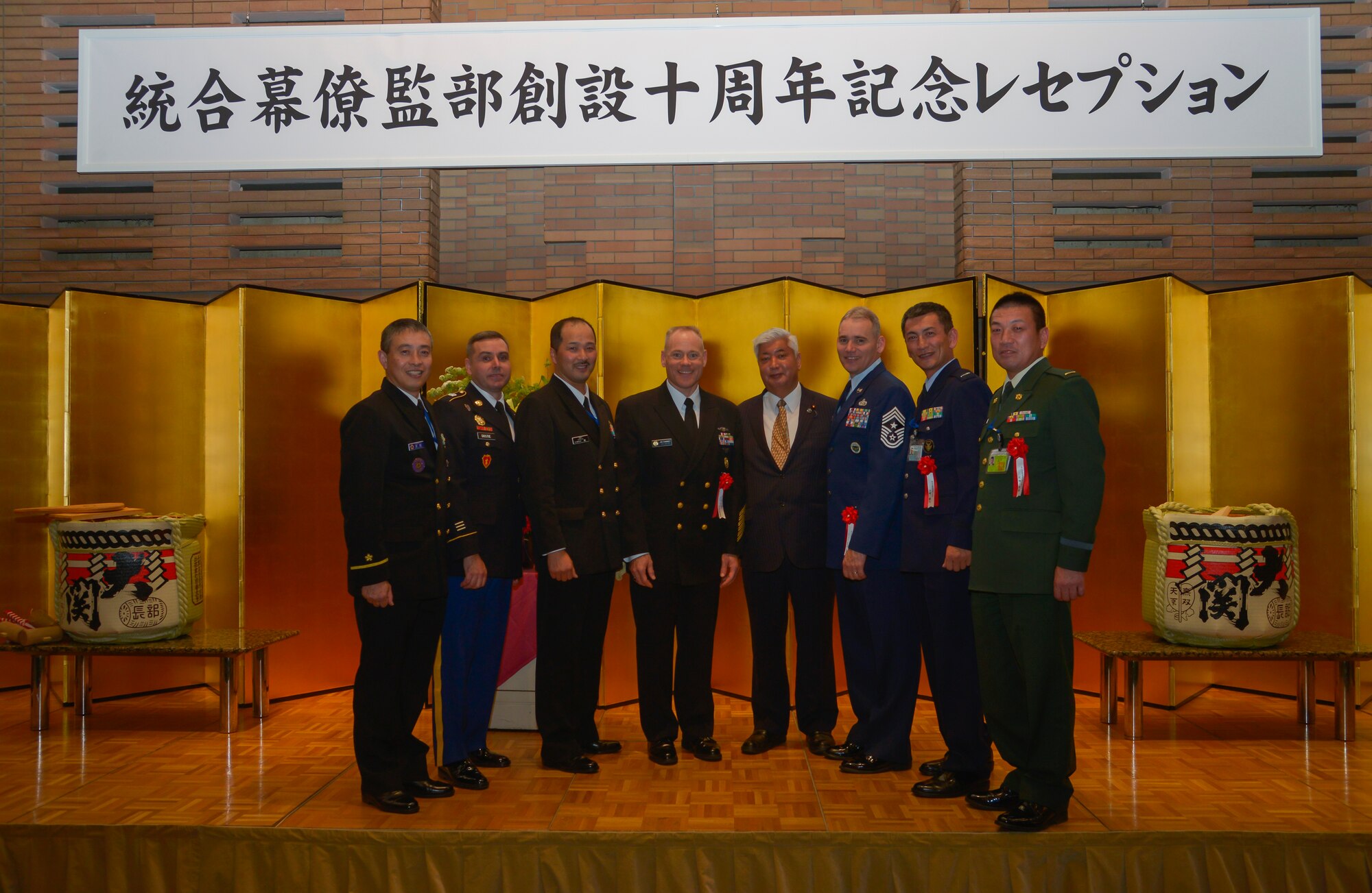 US service members and Japan Joint Staff pose with Gen Nakatani, Minister of Defense for Japan, for a picture during the Japan Joint Staff 10th anniversary ceremony at Hotel Grand Hill, Ichigaya, Japan, Feb. 17, 2016. The event consisted of opening remarks from senior leadership, breaking sake barrels and discussions between military personnel to strengthen bilateral relationships. (U.S. Air Force photo by Senior Airman David Owsianka/Released)