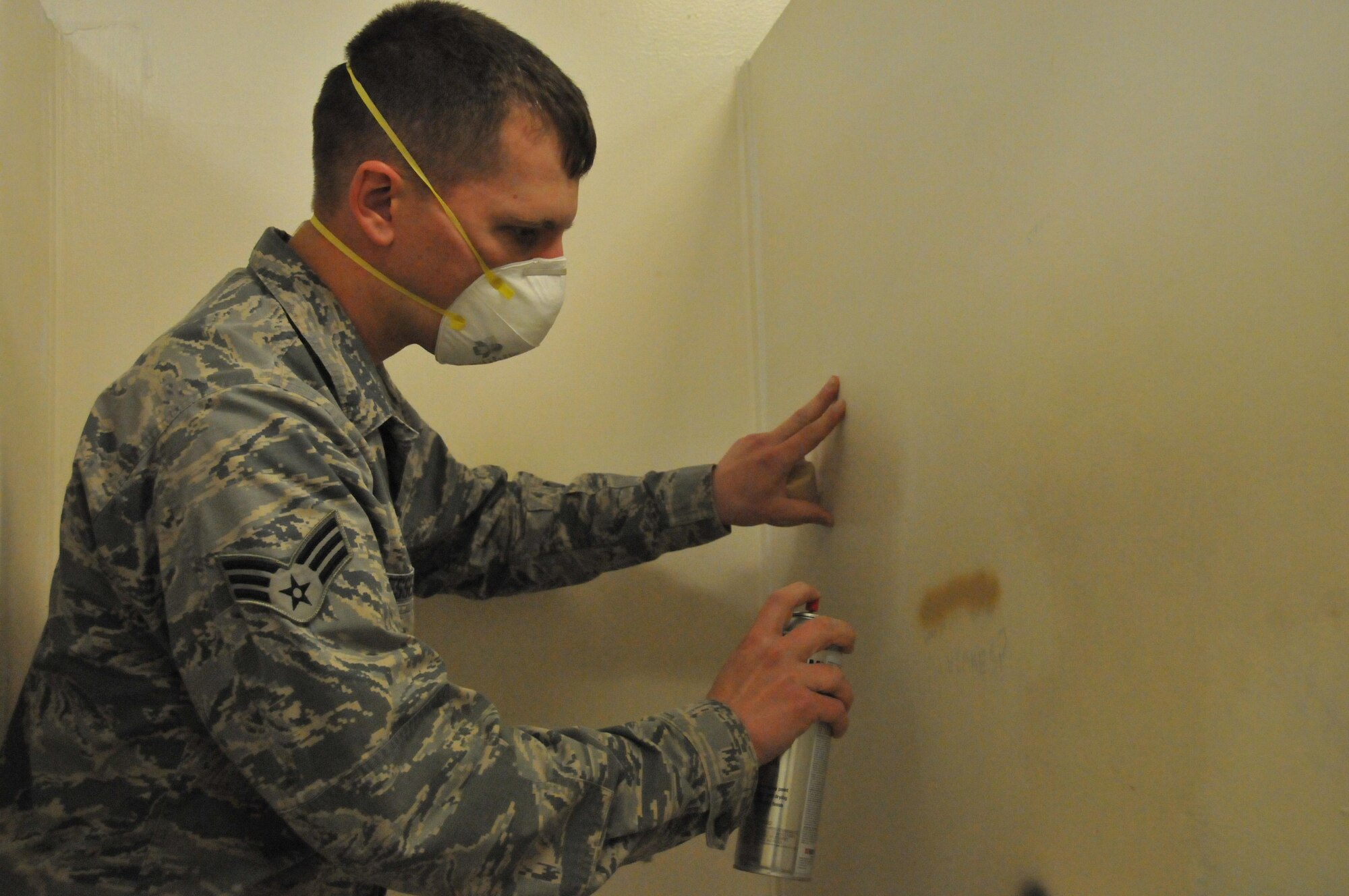 Senior Airman Bryce Hesselbacher, 379th Expeditionary Civil Engineer Squadron Cadillac maintenance team structural specialist, paints over graffiti in a toilet stall Feb. 12 at Al Udeid Air Base, Qatar. One of the jobs of the Cadillac maintenance team is to ensure the bathrooms are free of graffiti. Graffiti removal is accomplished every other day. (U.S. Air Force photo by Tech. Sgt. Terrica Y. Jones/Released)