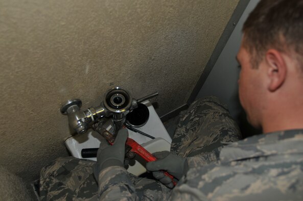 Airman 1st Class John Henkle, 379th Expeditionary Civil Engineer Squadron Cadillac maintenance team plumber, fixes a toilet Feb. 12 at Al Udeid Air Base, Qatar. Henkle replaces the diaphragm to enable the toilet to flush. (U.S. Air Force photo by Tech. Sgt. Terrica Y. Jones/Released)