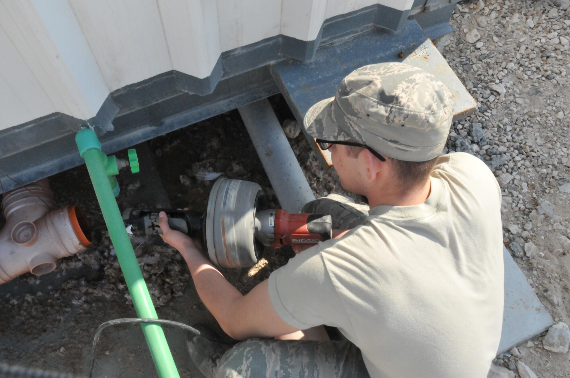 Airman 1st Class Roger Jama, 379th Expeditionary Civil Engineer Squadron plumber, uses a snake drill to unclog Cadillac toilets Feb. 12 at Al Udeid Air Base, Qatar. The snake drill is designed to loosen restrictions to reach the clogs that are deep within a pipe. (U.S. Air Force photo by Tech. Sgt. Terrica Y. Jones/Released)