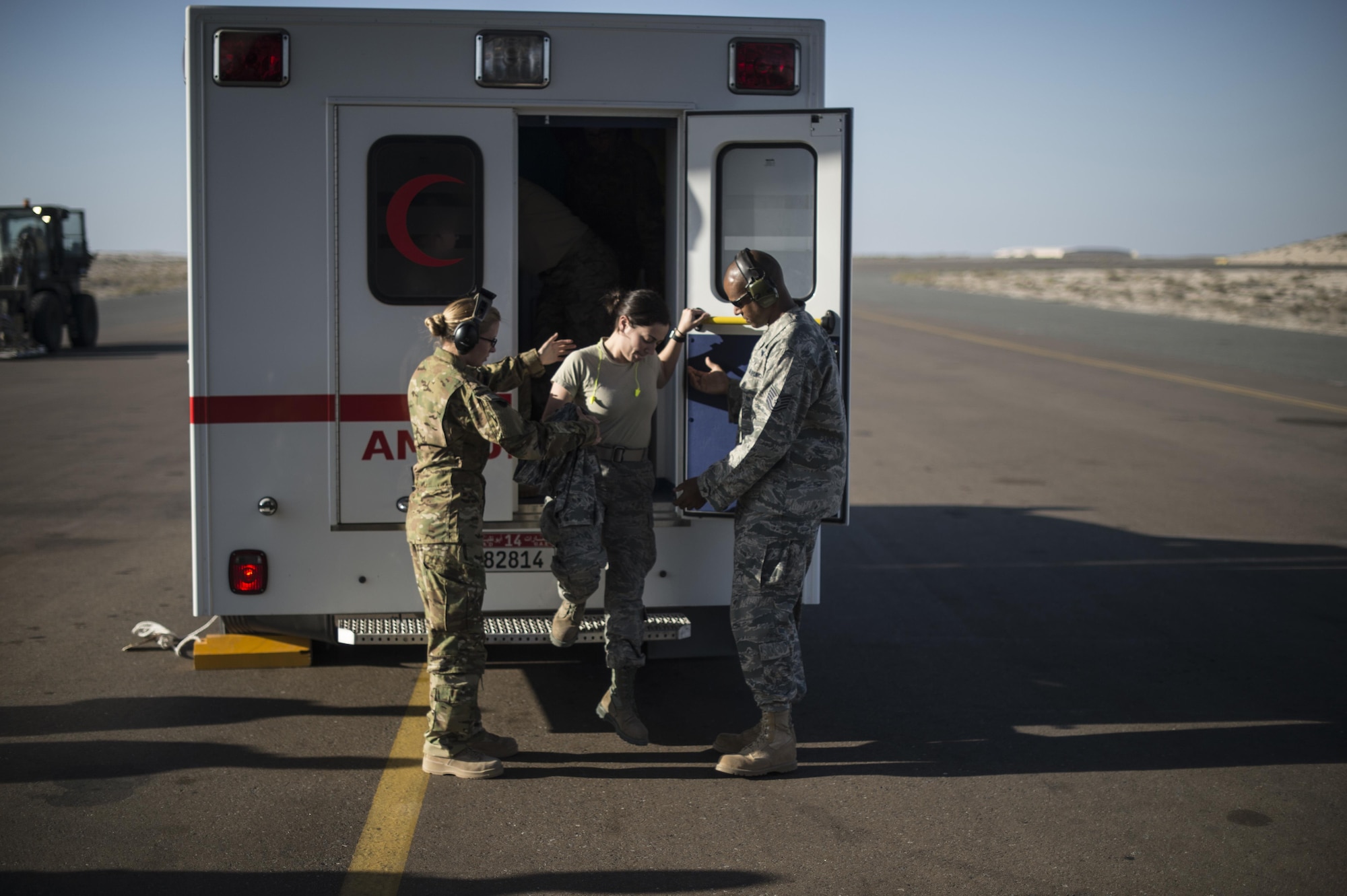 Members of the 379th Expeditionary Aeromedical Evacuation Squadron help a patient off an ambulance at an undisclosed location in Southwest Asia, Feb. 11, 2016. A typical 379th EAES mission includes transporting patients to locations with more definitive medical care or returning recovered personnel to duty at their deployed locations. (U.S. Air Force photo by Staff Sgt. Corey Hook/Released)
