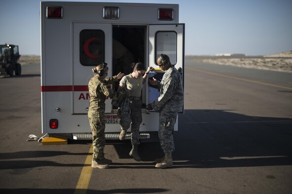 Members of the 379th Expeditionary Aeromedical Evacuation Squadron help a patient off an ambulance at an undisclosed location in Southwest Asia, Feb. 11, 2016. A typical 379th EAES mission includes transporting patients to locations with more definitive medical care or returning recovered personnel to duty at their deployed locations. (U.S. Air Force photo/Staff Sgt. Corey Hook)