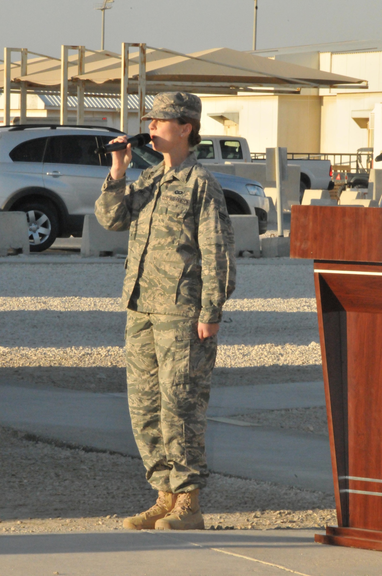 Senior Airman Michelle Doolittle, Air Force Central Command band vocalist, sings the national anthem during a retreat ceremony, Feb. 15, at Al Udeid Air Base, Qatar. The ceremony was held to honor George Washington’s Birthday. (U.S. Air Force photo by Tech. Sgt. Terrica Y. Jones/Released)