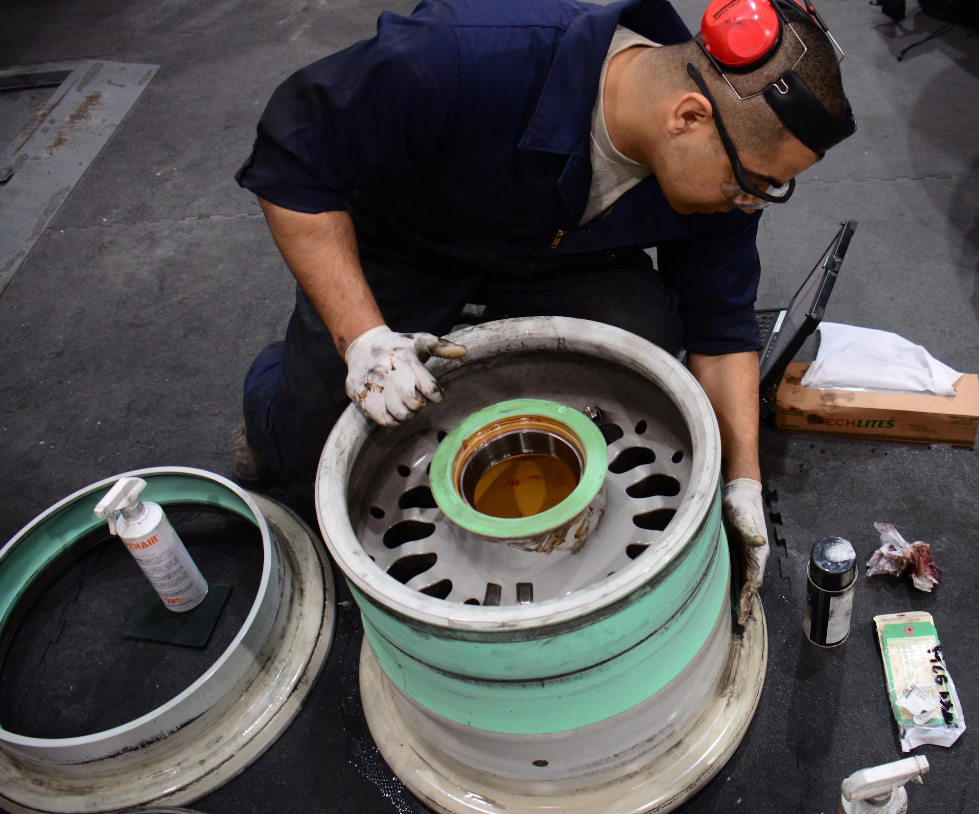Staff Sgt. Abraham Ponce, 379th Expeditionary Maintenance Squadron aerospace maintenance craftsman, from Odessa, Texas, cleans a wheel at Al Udeid Air Base, Qatar Feb. 16. Cleaning every wheel by hand is part of the process of wheel and tire repair. During the cleaning process, Ponce inspects the wheel for cracks and signs of corrosion. (U.S. Air Force photo by Tech. Sgt. James Hodgman/Released)