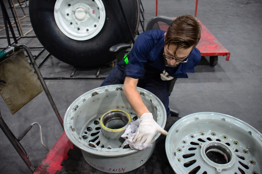 Senior Airman Michael Dalleo, a 379th Expeditionary Maintenance Squadron aerospace maintenance apprentice, from Enfield, Conn., cleans a wheel at Al Udeid Air Base, Qatar Feb. 16, 2016. Cleaning every wheel by hand is part of the process of wheel and tire repair. During the cleaning process, Dalleo inspects the wheel for cracks and signs of corrosion. (U.S. Air Force photo/Tech. Sgt. James Hodgman)
