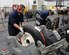 Staff Sgt. Abraham Ponce, left, a 379th Expeditionary Maintenance Squadron aerospace maintenance craftsman, from Odessa, Texas, and Airman 1st Class Bobbie Price III, a 379th Expeditionary Maintenance Squadron aerospace maintenance journeyman, from League City, Texas, work to repair two wheels at Al Udeid Air Base, Qatar Feb. 16, 2016. The squadron’s wheel and tire shop was the most productive in the Air Force last year. (U.S. Air Force photo/Tech. Sgt. James Hodgman)