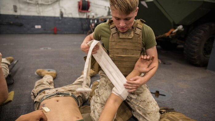 U.S. Marine Corps Lance Cpl. Kevan T. Steinman, a cannoneer with Battery B, 1st Battalion, 11th Marine Regiment, bandages a simulated wound during a Combat Life Saver Course aboard USS New Orleans, Oct. 28, 2015. Composite Training Unit Exercise allows Marines and sailors to further sharpen their skills and become a cohesive unit. COMPTUEX provides the Boxer Amphibious Ready Group/13th Marine Expeditionary Unit the opportunity to integrate planning while allowing focused, mission-specific training and evaluation for the Marines and their naval counterparts.