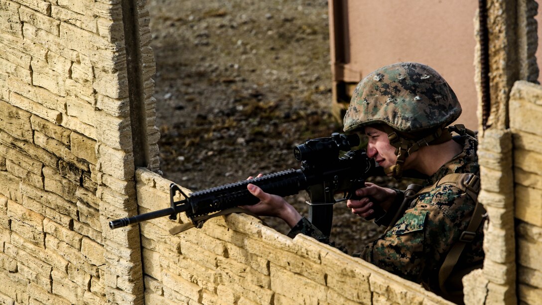 Lance Cpl. Thomas Ermert, a military policeman with Bravo Company, 2nd Law Enforcement Battalion, aims down the optics of his rifle during an interior guard training exercise at Forward Observation Base Hawk at Marine Corps Base Camp Lejeune, N.C., Feb. 17, 2016. The training prepared Marines to conduct real-life site security operations. 