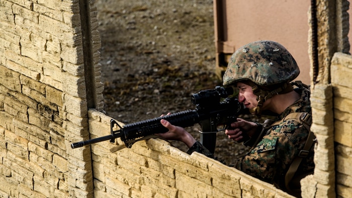 Lance Cpl. Thomas Ermert, a military policeman with Bravo Company, 2nd Law Enforcement Battalion, aims down the optics of his rifle during an interior guard training exercise at Forward Observation Base Hawk at Marine Corps Base Camp Lejeune, N.C., Feb. 17, 2016. The training prepared Marines to conduct real-life site security operations. 