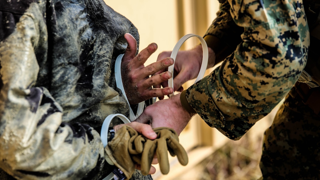 A Marine with Bravo Company, 2nd Law Enforcement Battalion, apply restraints to a role player during a simulation involving hostile, combative civilians during an interior guard training exercise at Forward Observation Base Hawk at Marine Corps Base Camp Lejeune, N.C., Feb. 17, 2016. The training prepared Marines to conduct real-life site security operations.