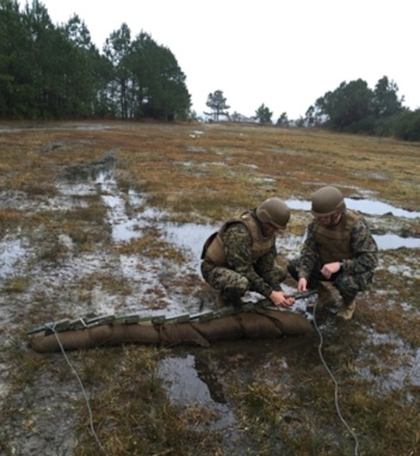 On February 4 2016, Second Lieutenants David A. Calderon and Trevor S. Isbell, students attached to Combat Engineer Officer course 1-16 (CEO 1-16) at Marine Corps Engineer School Camp Lejeune, N.C.; place an explosive charge on a notional captured enemy ammunition stack. Reducing captured enemy ammunition is one aspect of the combat engineer's task of explosive hazard destruction.
