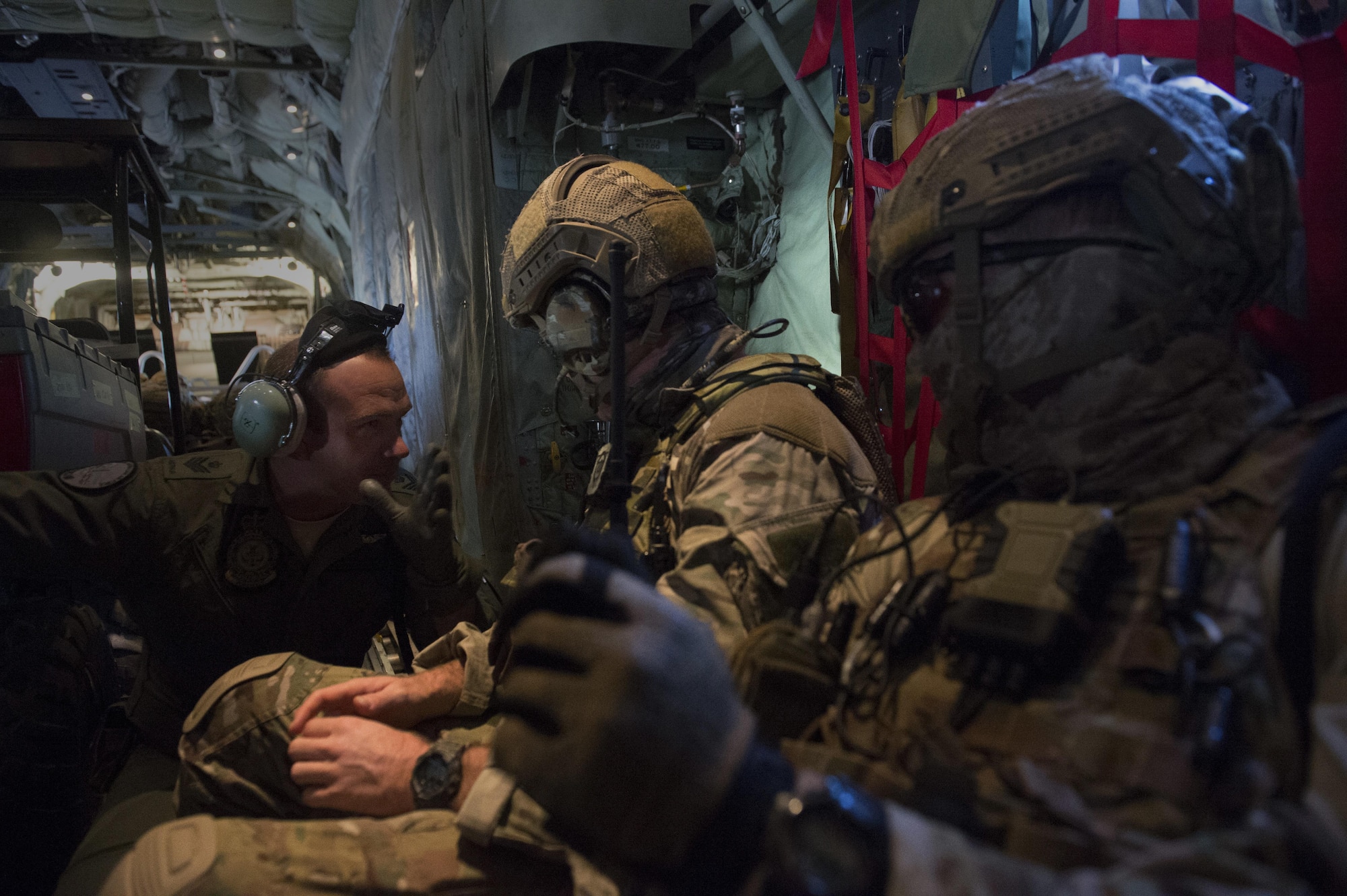 Royal Australian Air Force Sgt. Angus Shaw, a 37th Squadron loadmaster, left, talks with two 4th Squadron combat controllers aboard a C-130J Super Hercules during Exercise Cope North 2016 over Rota, Northern Mariana Islands, Feb. 12, 2016. Exercise The exercise includes 22 total flying units and nearly 3,000 personnel from six countries and continues the growth of strong, interoperable and beneficial relationships within the Asia-Pacific region through integration of airborne and land-based command and control assets. (U.S. Air Force photo/Staff Sgt. Matthew B. Fredericks)