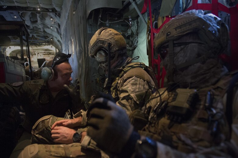 Royal Australian Air Force Sgt. Angus Shaw, a 37th Squadron loadmaster, left, talks with two 4th Squadron combat controllers aboard a C-130J Super Hercules during Exercise Cope North 2016 over Rota, Northern Mariana Islands, Feb. 12, 2016. Exercise The exercise includes 22 total flying units and nearly 3,000 personnel from six countries and continues the growth of strong, interoperable and beneficial relationships within the Asia-Pacific region through integration of airborne and land-based command and control assets. (U.S. Air Force photo/Staff Sgt. Matthew B. Fredericks)