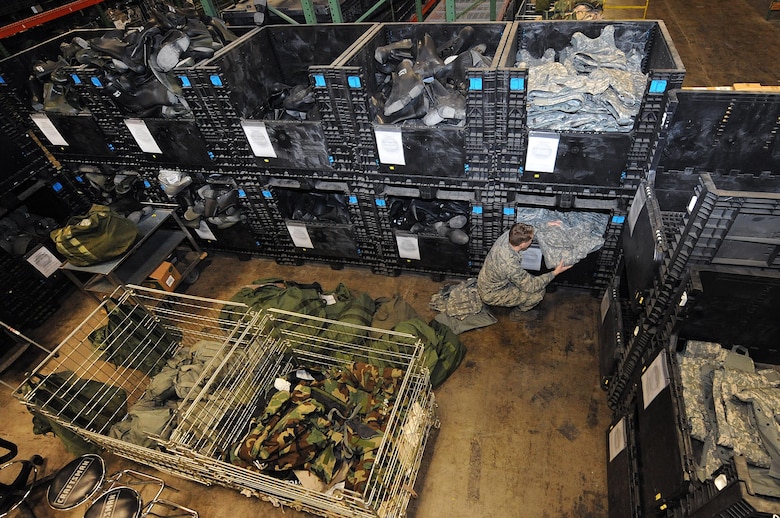Airman 1st Class Corey Lewis, a 509th Logistics Readiness Squadron materiel management journeyman, gathers an improved outer tactical vest for a deployment bag at Whiteman Air Force Base, Mo., Feb. 3, 2016. Depending on an Airman’s destination, they may require different items, from an advanced combat helmet, web belt and canteen to chemical defense gear and field items.  (U.S. Air Force photo/Airman 1st Class Michaela Slanchik)