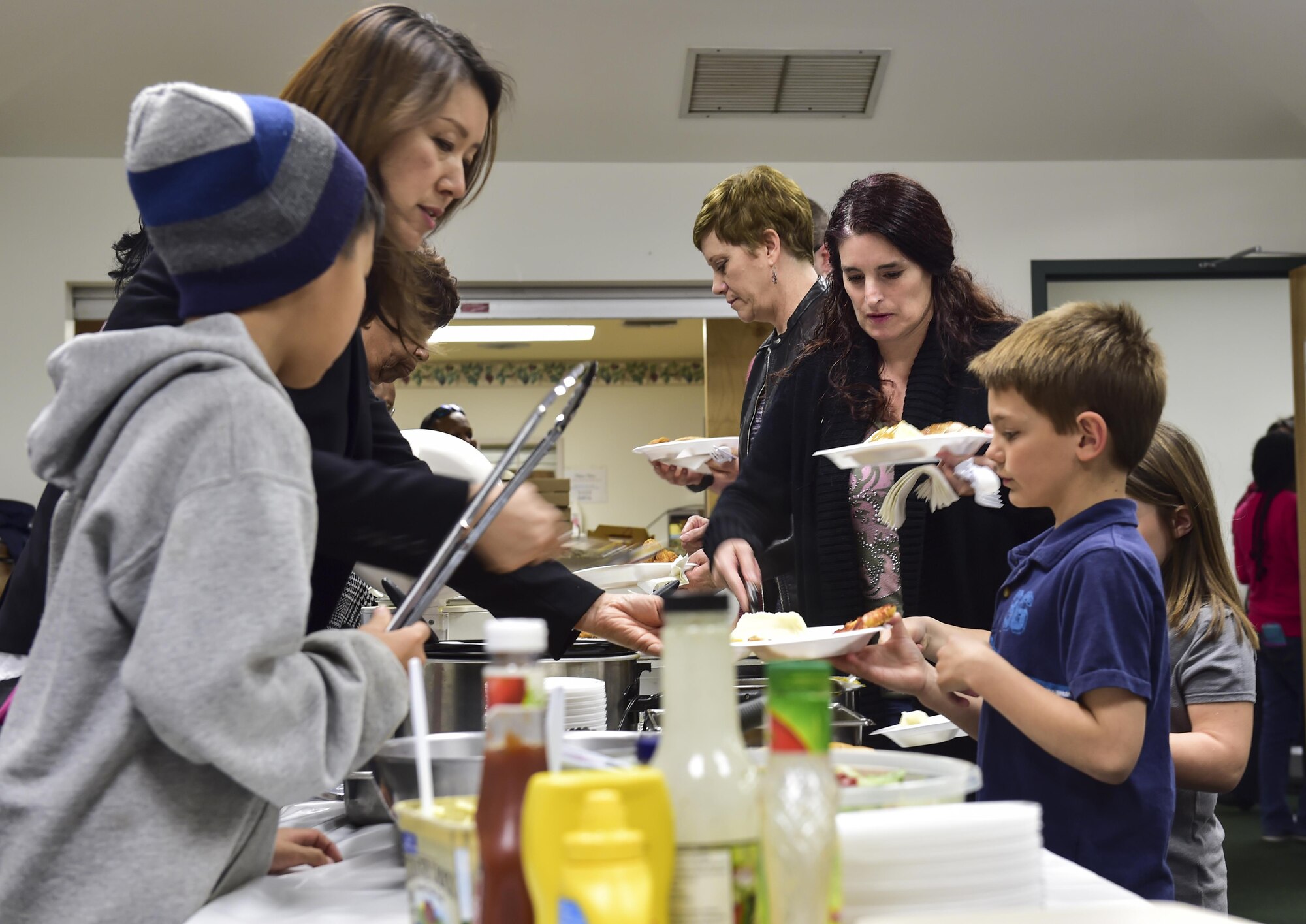 Families prepare food plates during a deployed families’ dinner at the chapel, Hurlburt Field, Fla., Feb. 11, 2016. The Hurlburt Field Chapel, in collaboration with the Airman & Family Readiness center, hosted the event to allow families of deployed members an opportunity to relax, socialize and interact with one another. (U.S. Air Force photo by Senior Airman Jeff Parkinson)