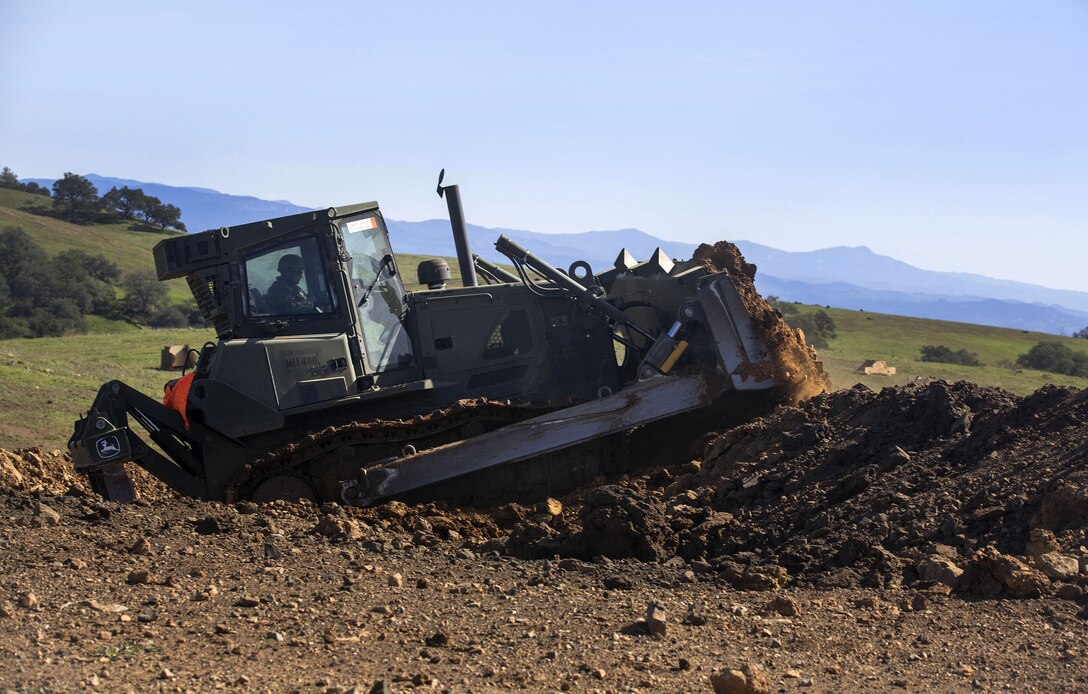 A Marine operates a bulldozer to clear dirt and debris from a breaching lane created by a mine clearing line charge during breaching training that's part of Exercise Iron Fist conducted on Marine Corps Base Camp Pendleton, Calif., Feb. 4, 2016. Marine Corps photo by Cpl. Garrett White