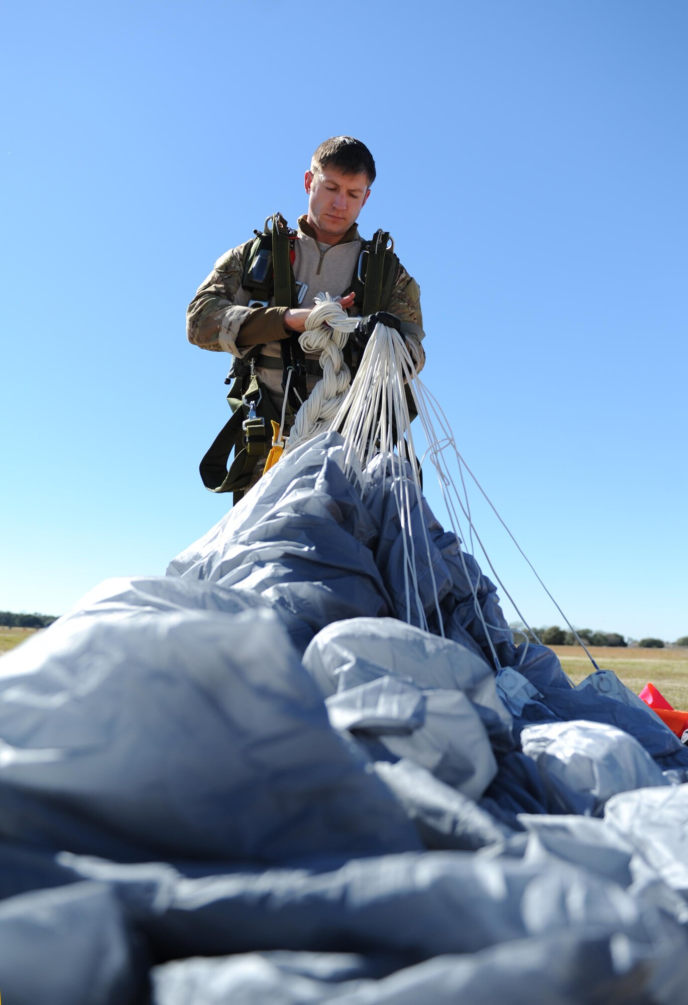 Staff Sgt. James, 334th Training Squadron combat control instructor, gathers his parachute following a jump Feb. 17, 2016, Keesler Air Force Base, Miss. Keesler’s battlefield Airmen instructors periodically perform the routine training exercise to maintain their proficiency. (U.S. Air Force photo by Kemberly Groue)