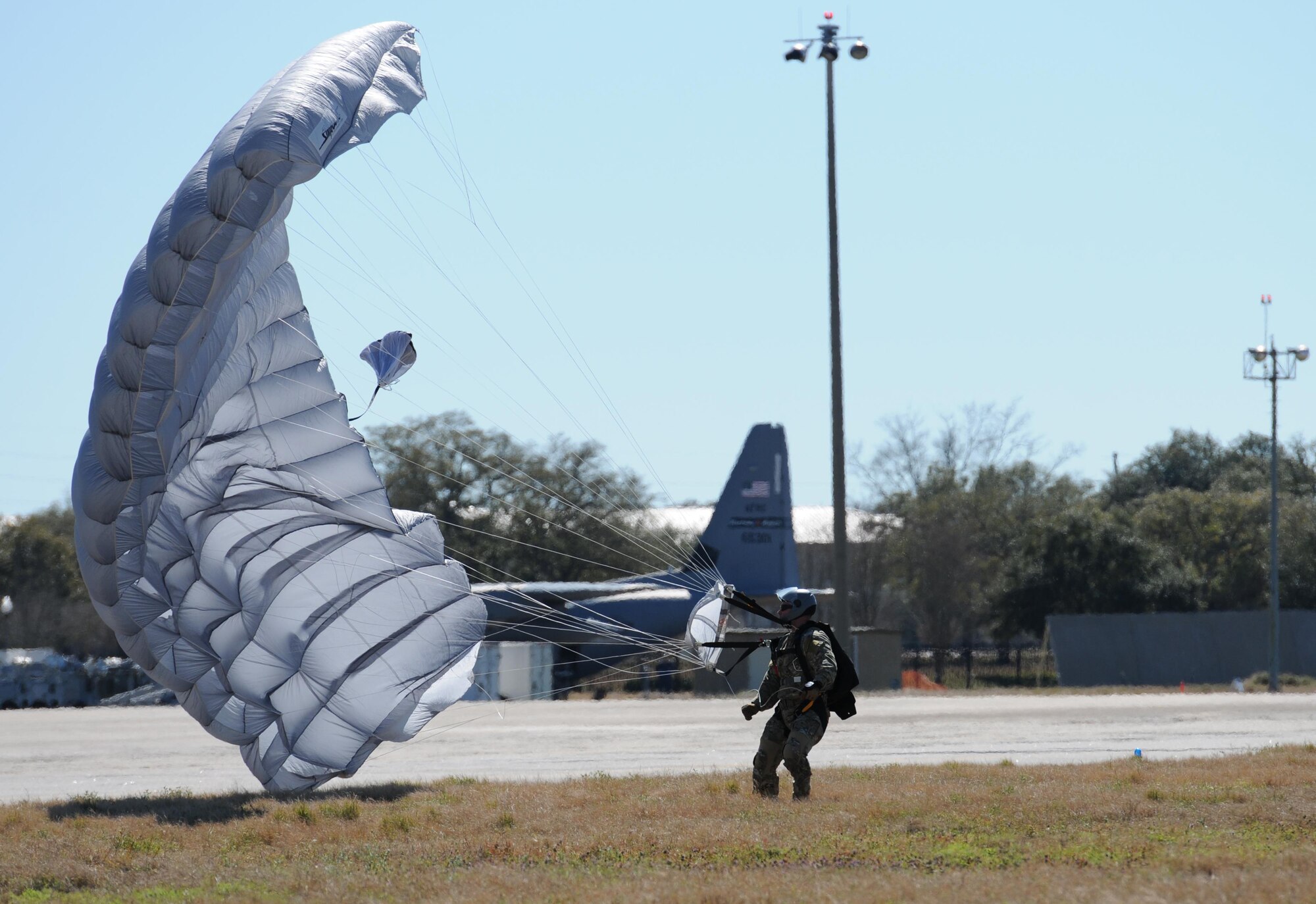 Master Sgt. Yuri, 334th Training Squadron combat control instructor, makes a successful parachute landing on the flight line Feb. 17, 2016, Keesler Air Force Base, Miss. Keesler’s battlefield Airmen instructors periodically perform the routine training exercise to maintain their proficiency. (U.S. Air Force photo by Kemberly Groue)